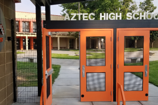 Main entrance to Aztec High School showing secured gates and campus courtyard in Aztec, New Mexico.